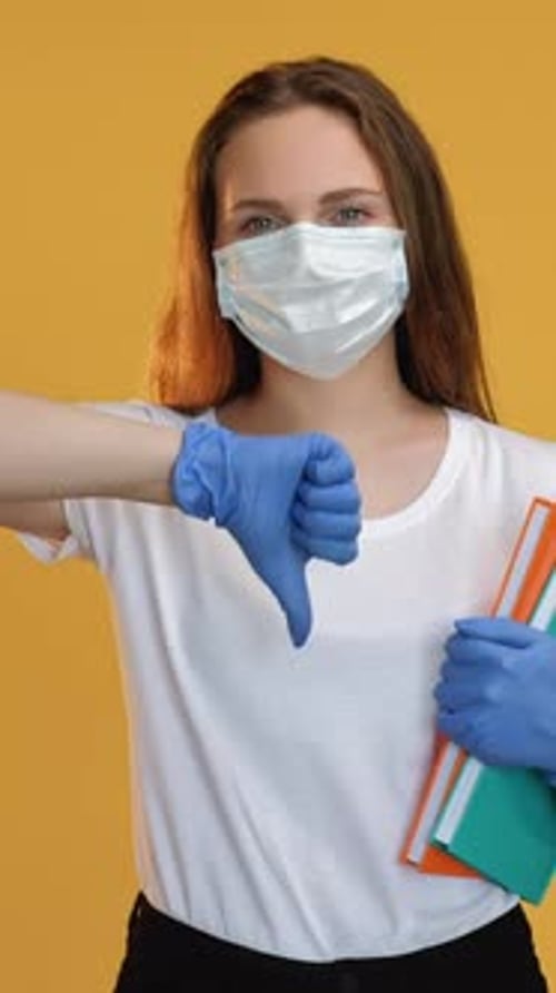 Woman with Mask Gives Thumbs Down Gesture