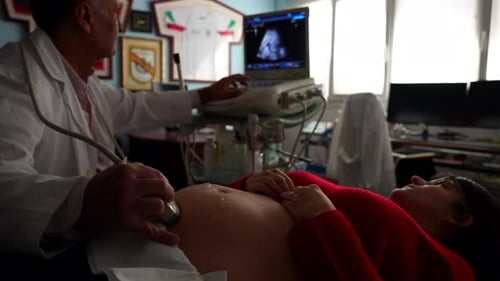 Gynecologist locating baby with ultrasound Close-up on belly, 4K