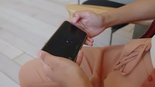 Hands of Anonymous Woman Holding Smartphone with Music Player App