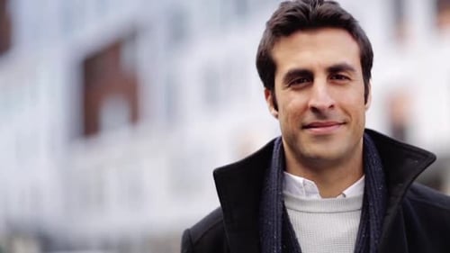 Homem hispânico feliz sorrindo ao ar livre na cidade com expressão facial alegre