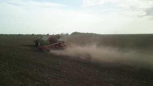 Grüner Traktor, der Weizen auf dem Feld sät