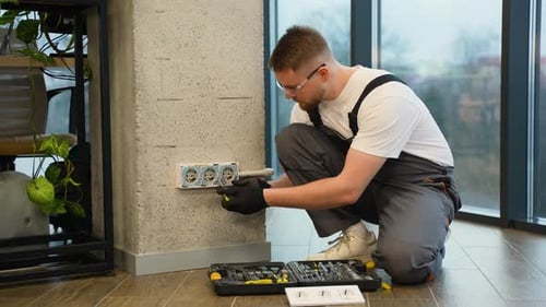 Professional Electrician Installing a Wall Socket Outlet