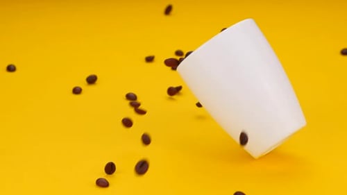 Coffee Beans Spilling from a White Mug