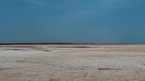 Salt desert landscape stretching under blue sky in Rann of Kutch, Gujarat, India