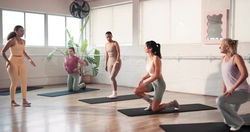Women's Fitness Class Stretching on Mats Indoors