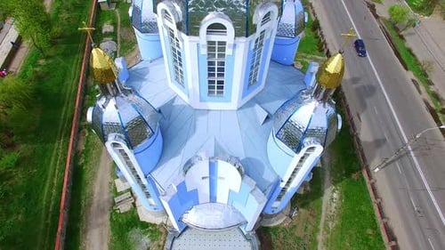 Beautiful orthodox cathedral on the picturesque riverbank. Scenery of Ukrainian city from top view.