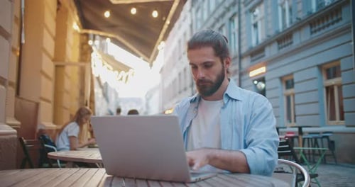 Young Adult Working on Laptop at Cafe