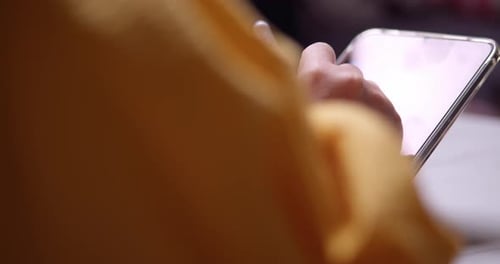 Close-up of a woman writing something on her electronic tablet using a digital stylus pen.