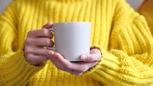 Holding a Warm Mug in a Yellow Sweater