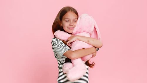Girl Hugging a Pink Plush Rabbit Toy