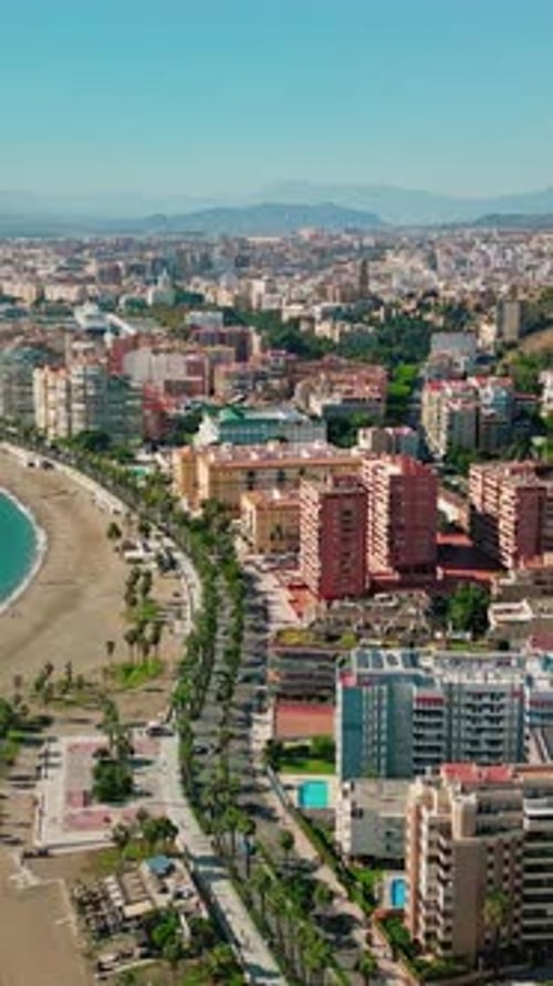 Vertical Aerial Pan from Málaga Coastal Skyline to Malagueta Beach, Spain