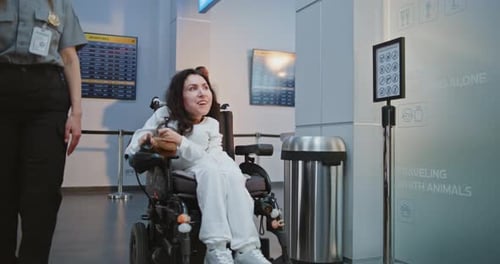 Airport Worker Walks with Passenger with Disability at Security Checkpoint for Screening Procedures