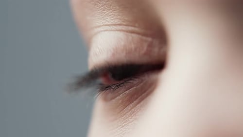 Junge kaukasische Frau mit blauen Augen schaut in Makro-Nahaufnahme des Studios weg