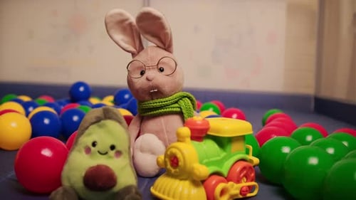 Brinquedos infantis brilhantes, coelho macio com óculos e cachecol, abacate e trem de brinquedo com cores