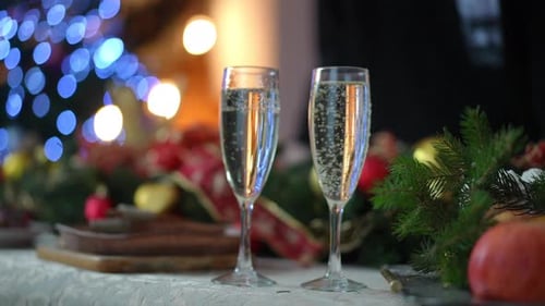 Festive Champagne Glasses with Christmas Tree Background