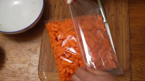 Bag of Pre-Cut Carrots on a Wooden Board