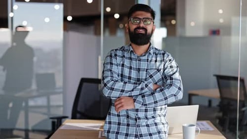 Portrait Young Confident Businessman Smiling with Crossed Arms in Modern Office