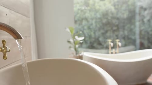 Close up of washbasin with running water in bathroom, slow motion