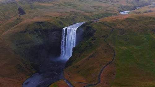 Skogafoss Waterfall Flowing Through Green Cliffs in Iceland