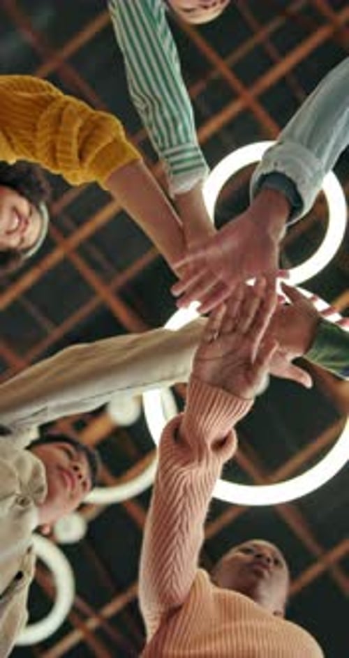 Group of Young Adults Stacking Hands in Teamwork