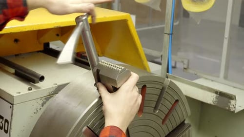 Metalldrehmaschine, Arbeiter demontiert das Spannfutter