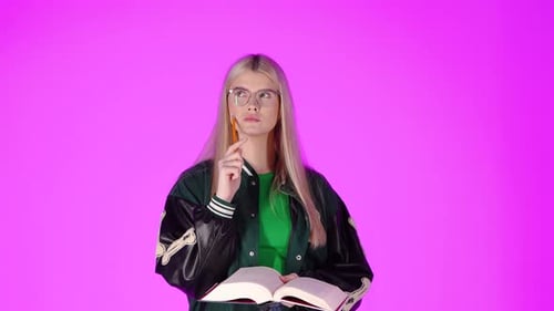 Serious Young Blonde Student, Reading a Book and Thinking, Studio Portrait With Pink Background