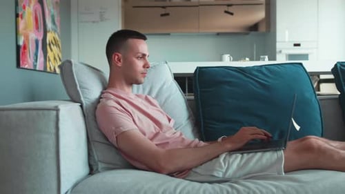 Man Relaxing at Home Using a Laptop
