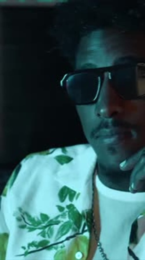 Portrait of audio engineer or producer working in music recording studio with LED light next to comp