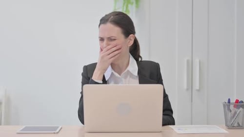 Woman Coughing at Her Desk in Office