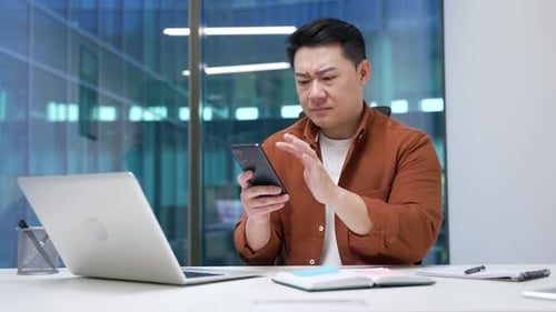 Man Using Mobile Phone at Office Desk
