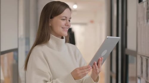 Woman Using Tablet Device for Online Meeting in Office