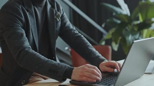 Concentrated Businessman Typing on Laptop at Office Workplace
