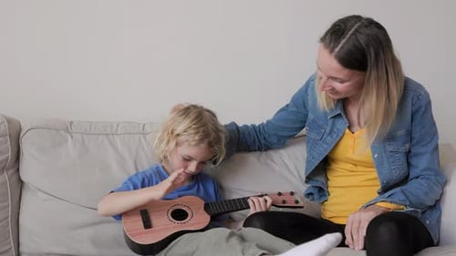 Woman and Child Playing Guitar at Home