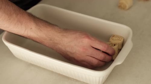 Arranging Dough Rolls in Baking Dish for Baking