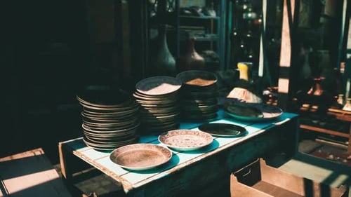 Stacked Plates and Bowls Displayed on a Wooden Table in a Market