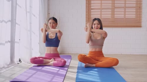 Women Practicing Yoga Stretch in Bright Studio