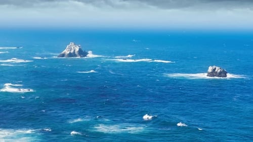 Ondas do mar quebram em Stone Rock Cliff ou Sea Rocks Islands em Blue Ocean RED