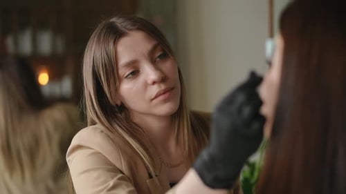 Beautiful Concentrated Young Woman Coloring Client Eyebrows in Beauty Spa Portrait of Focused