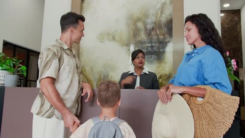 Friendly Receptionist Talking to Family during Check In at Hotel