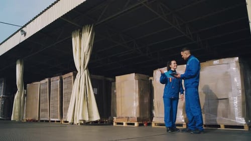 Warehouse Workers are Discussing the Delivery of Goods and the Movement of Goods in the Warehouse
