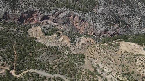 Drohnenblick: Riesiger Canyon, der sich zwischen zwei großen Bergen, Berghügeln mit landwirtschaftlichen Flächen gebildet hat