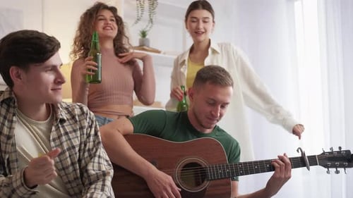 Friends Playing Guitar and Singing at Party