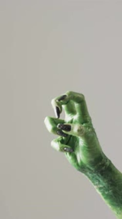 Vertical video of halloween green monster hand with copy space on grey background