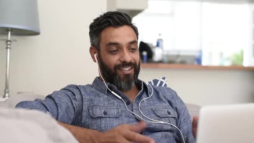 Man Video Conferencing on Laptop in Living Room
