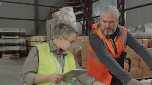 Man Bringing Cardboard Box to Female Manager for Sticking Barcode at Warehouse