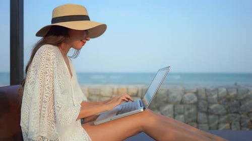 Weibliche Reisende oder digitale Nomadin, die aus der Ferne an einem Laptop arbeitet und vielleicht einen Blog im Internet schreibt