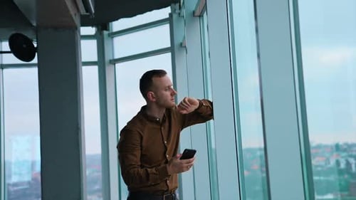 Serious businessman looking through the window.