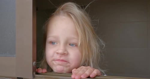 Blond Haired Girl Looking Out a Window