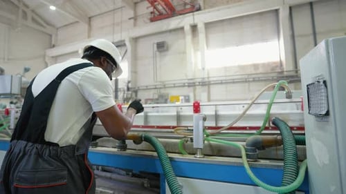 Black Engineer in Uniform with Tablet Checks the Cooling System at the Factory