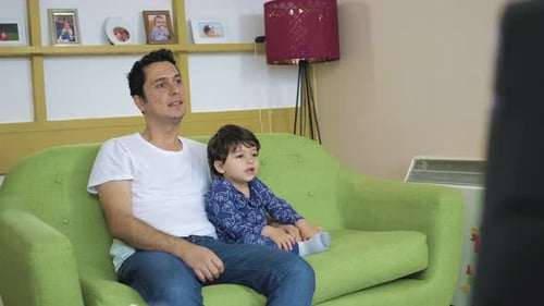 Father and Child Relaxing on Green Sofa